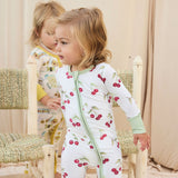 Two children wearing hand-painted pajamas standing in a softly lit room.