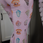Pink leggings with shell pattern worn by a person, blurred background